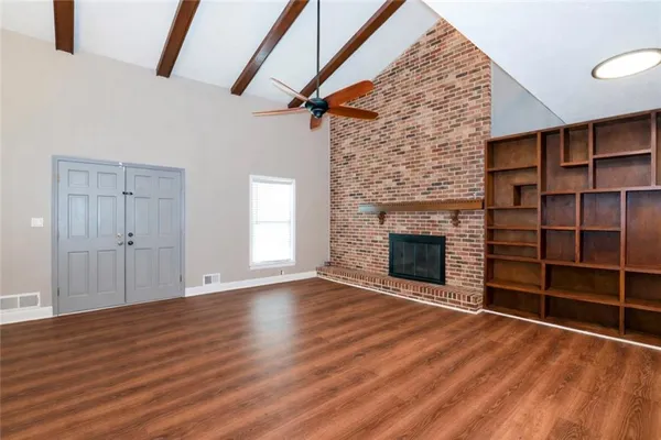 wooden floor fireplace and windows in an empty room