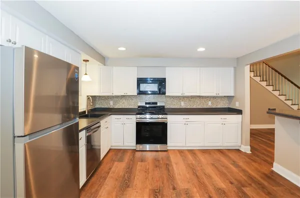 a kitchen with granite countertop stainless steel appliances and wooden cabinets