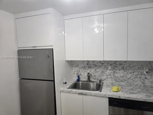 a kitchen with a refrigerator and cabinets