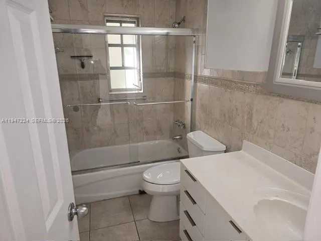 a white toilet sitting next to a shower