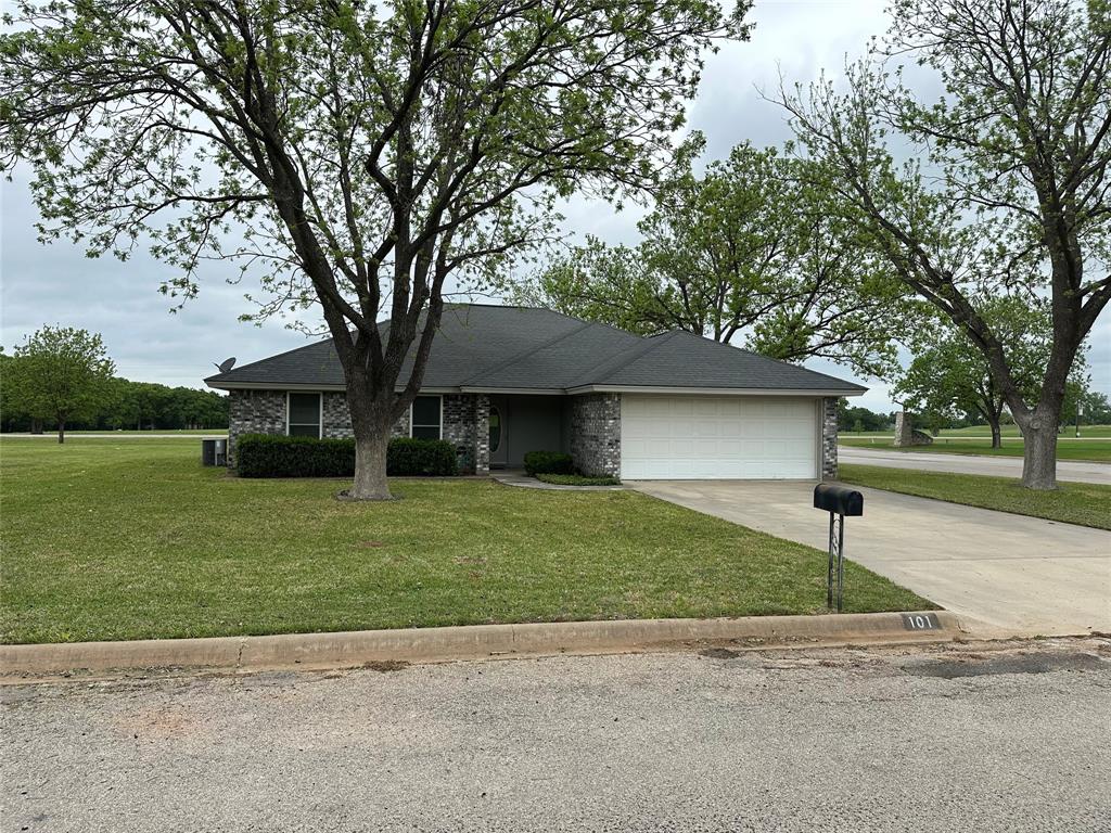 101 Player Street Comanche, TX 76442 - Photo 2 of 4 a front view of a house with a yard and garage