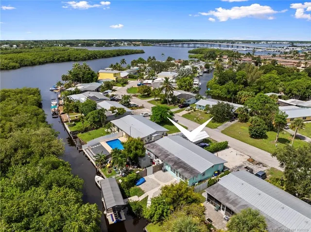 an aerial view of residential houses with outdoor space and ocean view