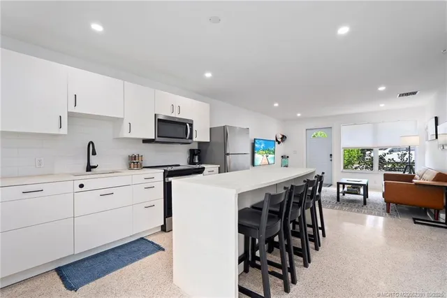 a living room with furniture a refrigerator and a coffee table