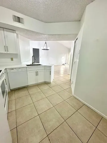 a kitchen with a sink a stove cabinets and counter space