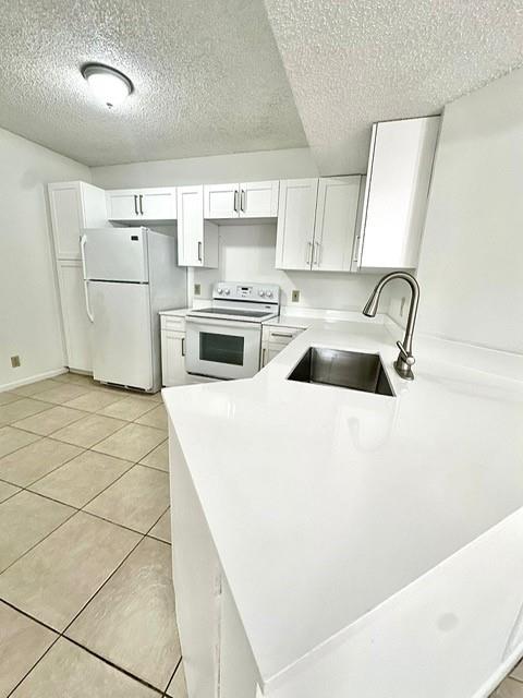 9033 Wiles Road, Unit 304 Coral Springs, FL 33067 - Photo 3 of 12 a kitchen with a stove a refrigerator and white cabinets