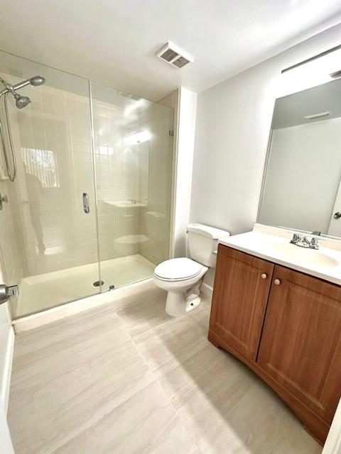 9033 Wiles Road, Unit 304 Coral Springs, FL 33067 - Photo 9 of 12 a bathroom with a double vanity sink toilet and shower