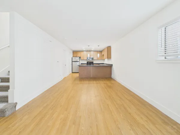 a view of a kitchen with wooden floor and a sink