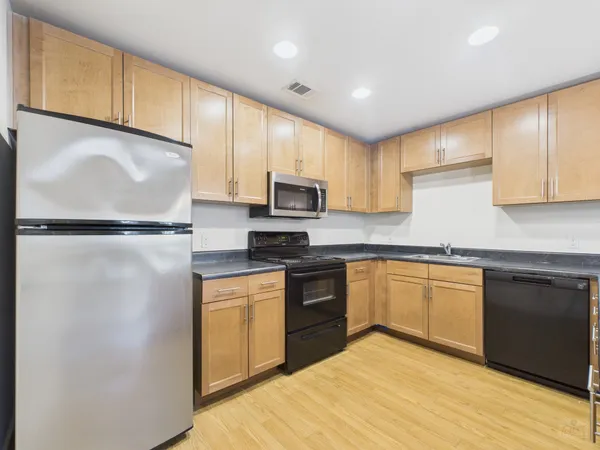 a kitchen with granite countertop stainless steel appliances and refrigerator