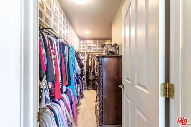 a view of walk in closet with clothes