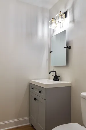 a bathroom with a sink a toilet and mirror