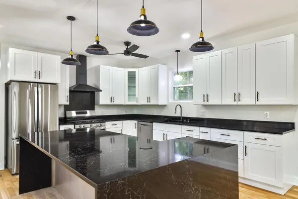 a kitchen with stainless steel appliances granite countertop a sink a stove and a refrigerator