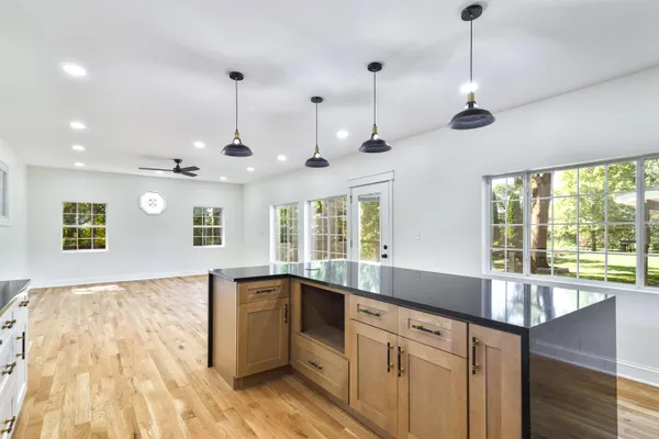 a large kitchen with stainless steel appliances granite countertop a sink and a large window