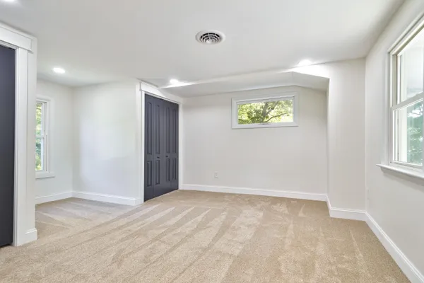 an empty room with windows and closet