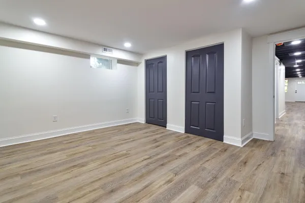 a view of an empty room with wooden floor