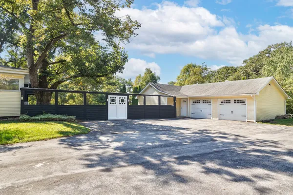 a view of a house with a yard and large tree