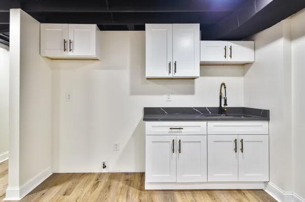 a kitchen with white cabinets and sink