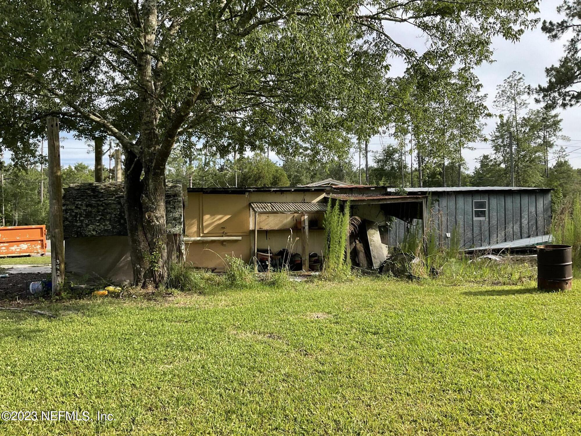 1365 US 90 Macclenny, FL 32063 - Photo 13 of 16 a view of a backyard with table and chairs and a large tree