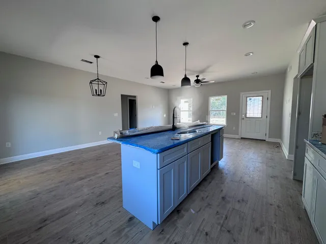a kitchen with stainless steel appliances granite countertop a sink a counter space and wooden floor