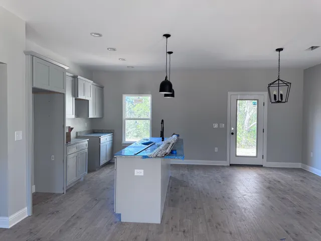 a kitchen with stainless steel appliances granite countertop a sink a stove a refrigerator and island