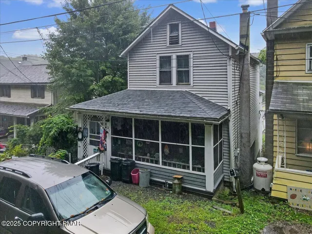 a view of house with a big yard and potted plants