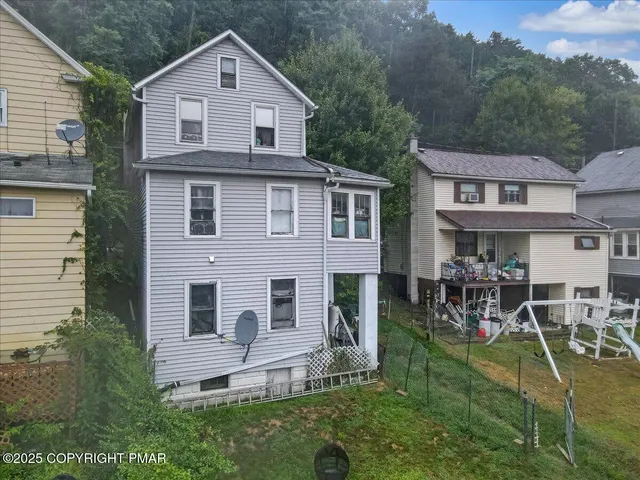 a aerial view of a house next to a yard
