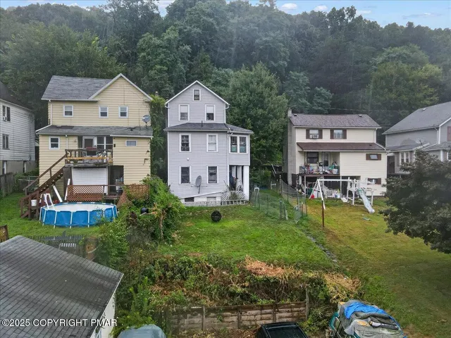aerial view of a house with garden space and street view