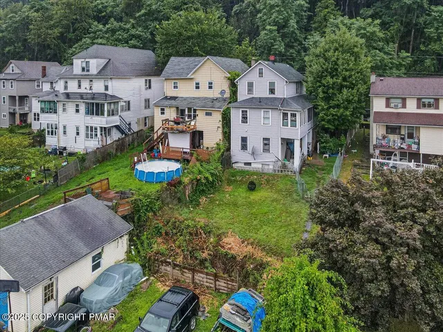 an aerial view of residential houses with outdoor space and trees
