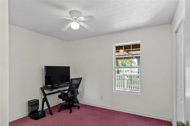 a view of a workspace with furniture and a window