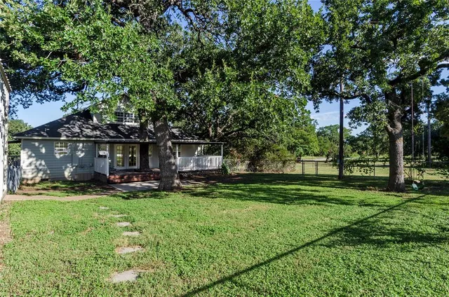 a view of a house with a yard and sitting area