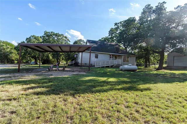 a view of a house with backyard and sitting area