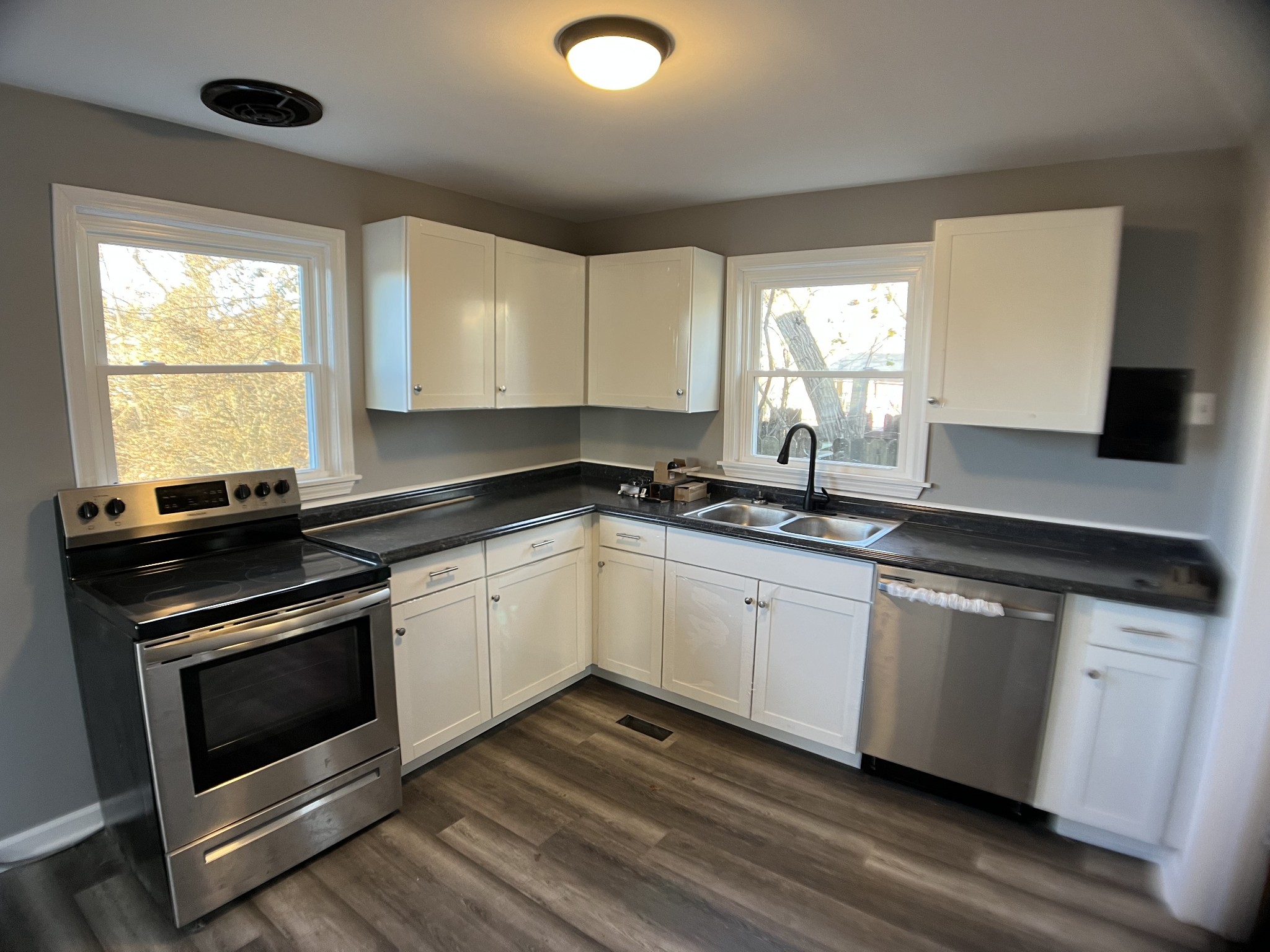 124 Arnold Lane Murfreesboro, TN 37127 - Photo 7 of 14 a kitchen with granite countertop white cabinets appliances a sink and a large window