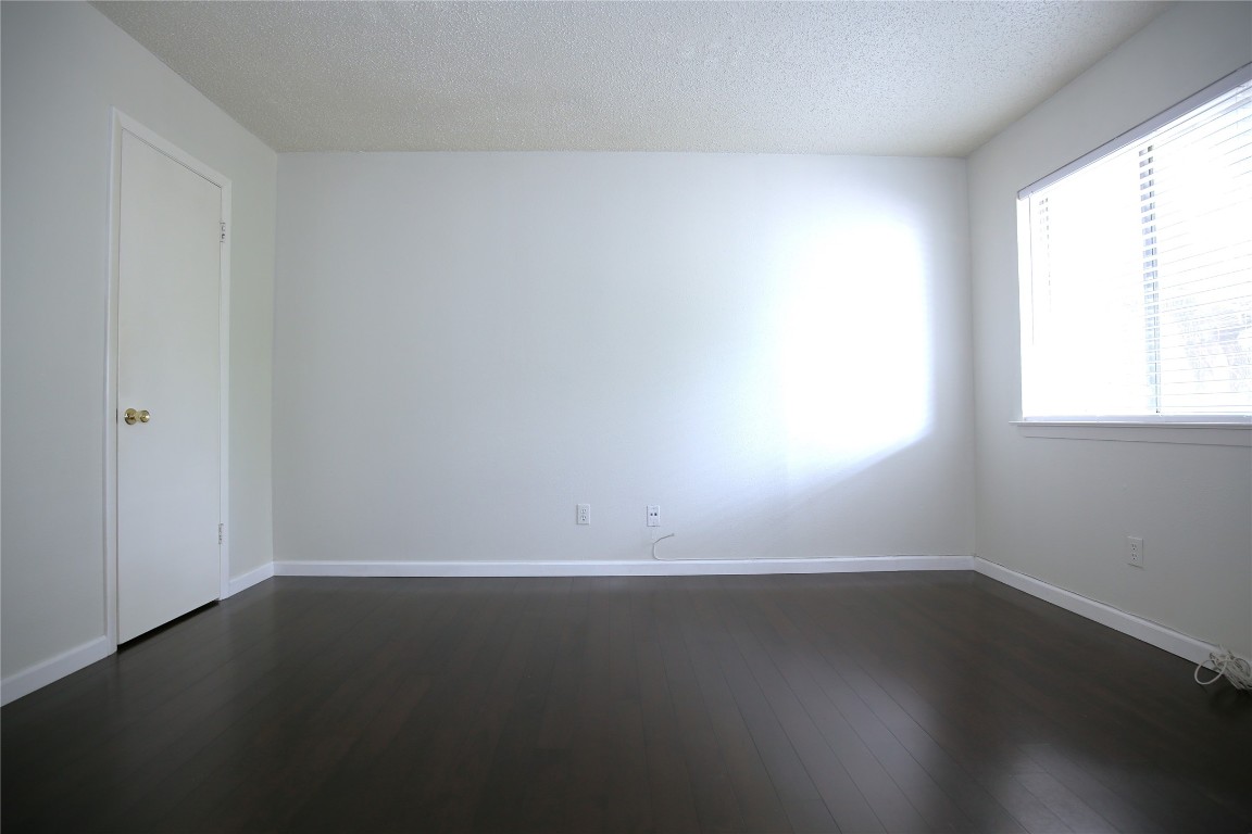 8210 Bent Tree Road, Unit 257 Austin, TX 78759 - Photo 11 of 20 an empty room with wooden floor and windows