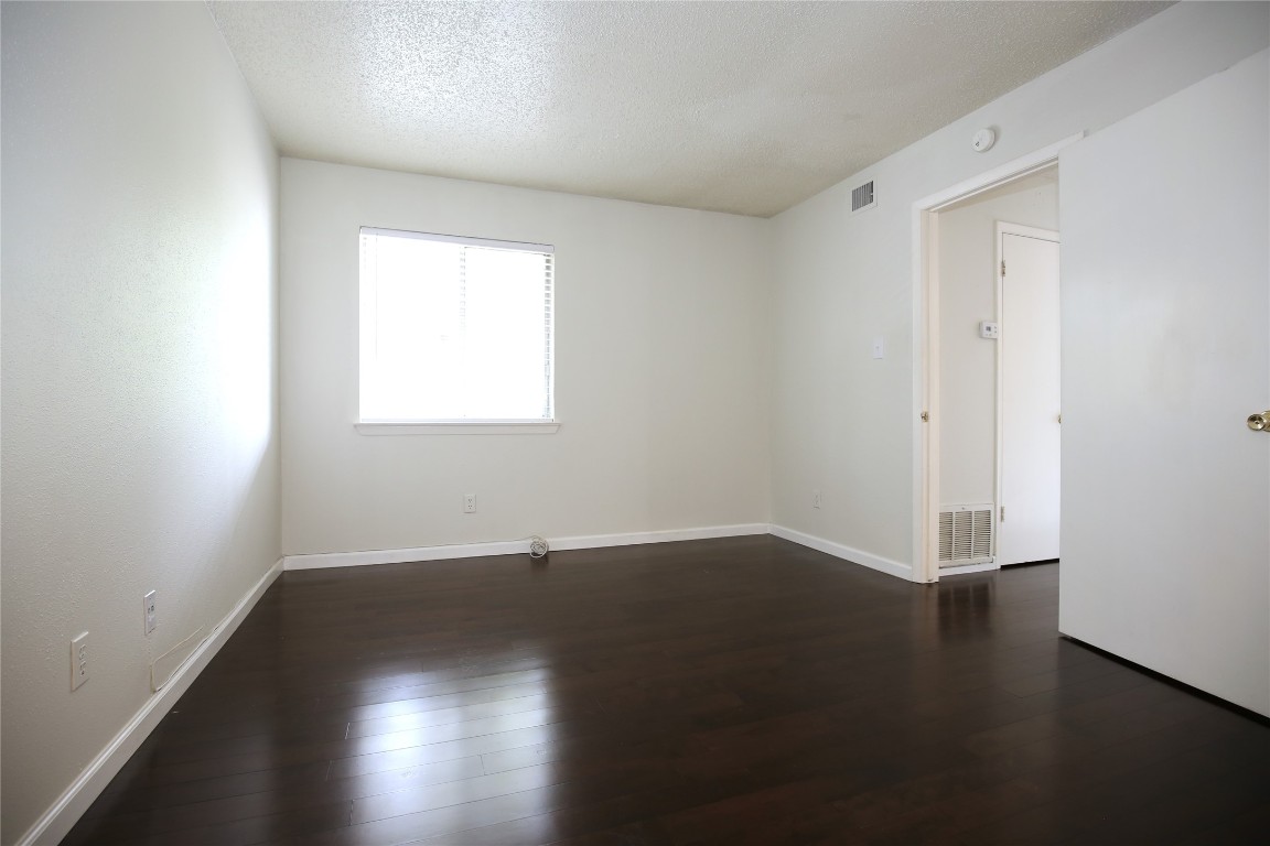 8210 Bent Tree Road, Unit 257 Austin, TX 78759 - Photo 14 of 20 an empty room with wooden floor and windows
