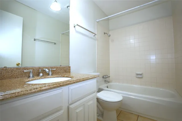 a bathroom with a granite countertop sink toilet a shower and a mirror
