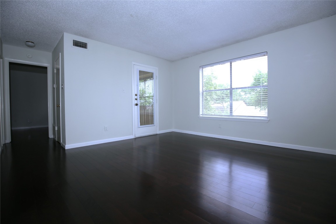 8210 Bent Tree Road, Unit 257 Austin, TX 78759 - Photo 4 of 20 a view of an empty room with wooden floor and a window