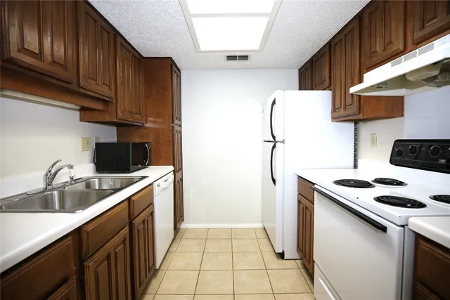 a kitchen with a sink a refrigerator and cabinets