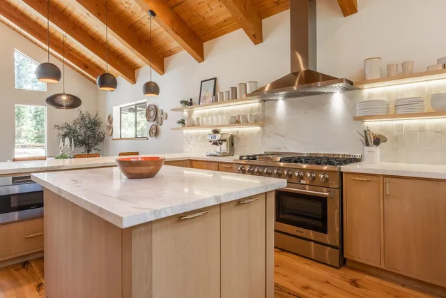 a kitchen with stainless steel appliances granite countertop a sink and a stove