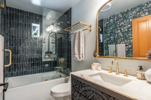 a bathroom with a sink a toilet and shower