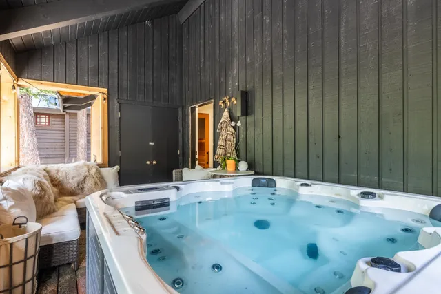a bathroom with a tub sink and mirror