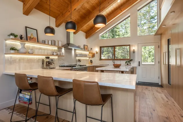 a kitchen with stainless steel appliances granite countertop a table chairs and wooden cabinets