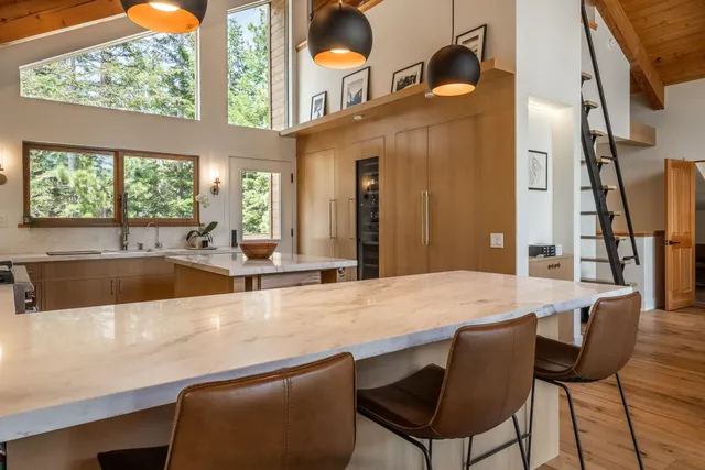 a large white kitchen with a stove and a large window