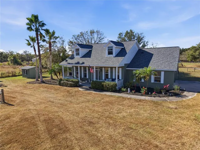 a view of a house with a yard and sitting area