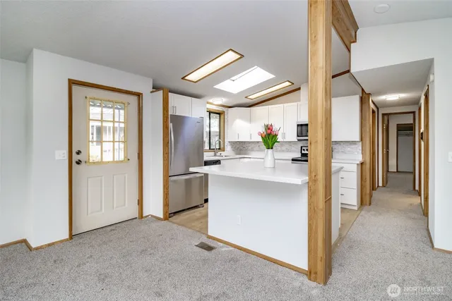 a view of kitchen with refrigerator and window