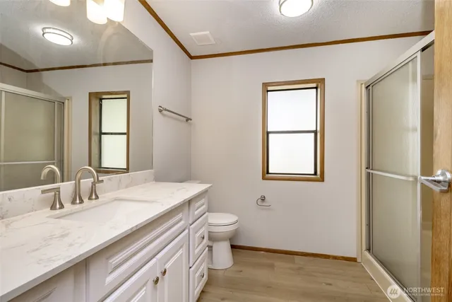a bathroom with a granite countertop sink toilet and a mirror