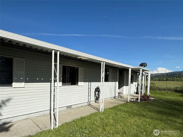 a view of a house with backyard and a patio