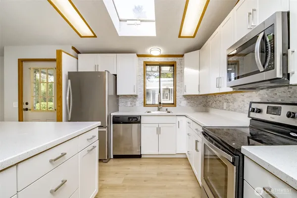 a kitchen with stainless steel appliances a refrigerator sink and stove