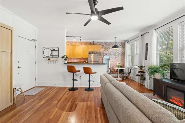 a living room with furniture a flat screen tv and a large window