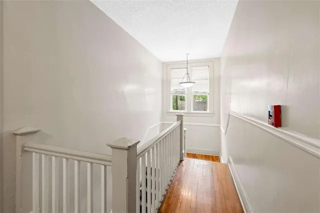 a view of a hallway with wooden floor and staircase