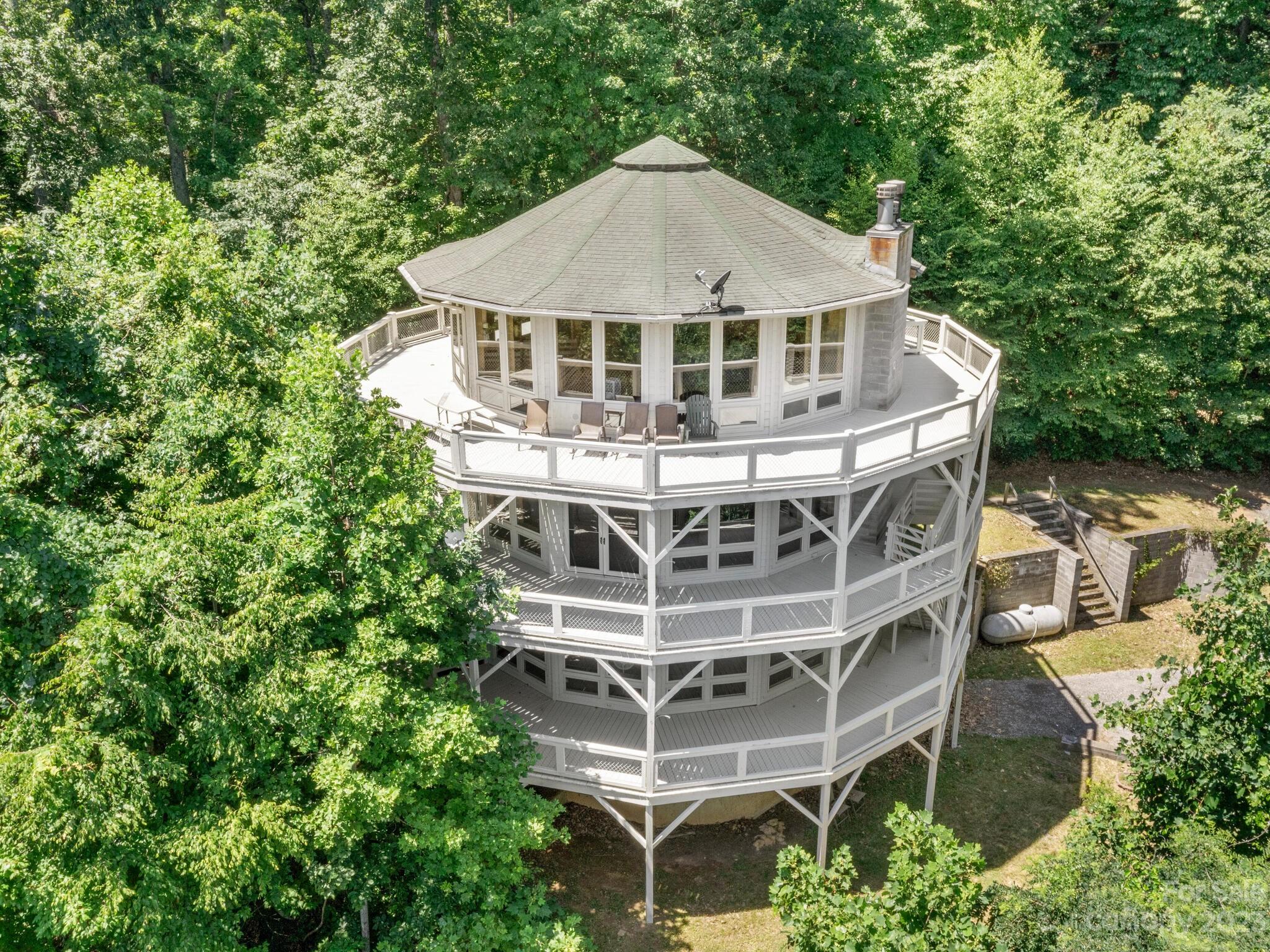 a tall glass building with trees in the background