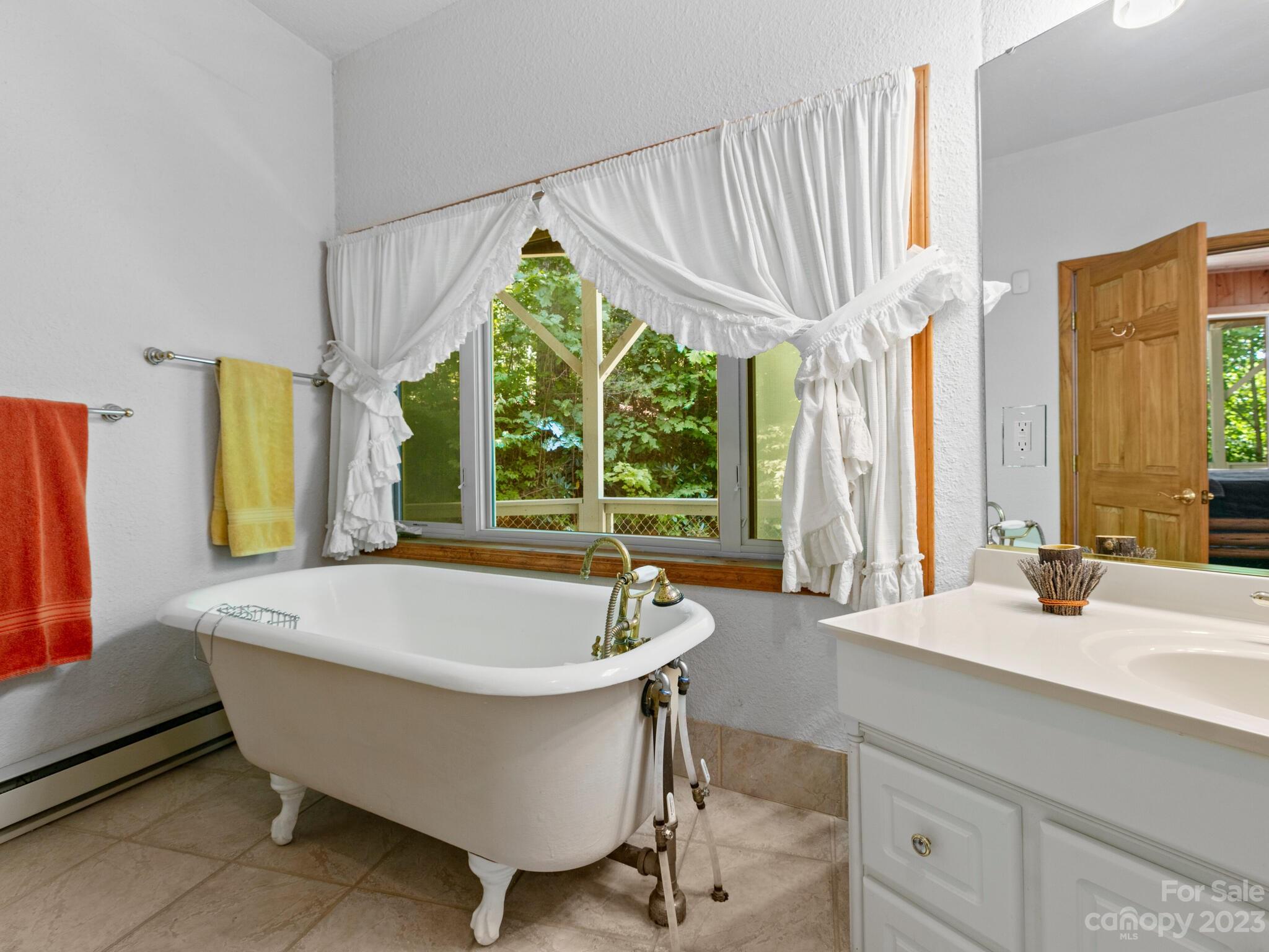 39 Rising Sun Road Candler, NC 28715 - Photo 25 of 41 a bath tub sitting in a bathroom next to a window